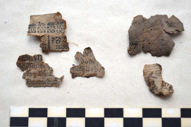 Dochované fragmenty papíru s tištěným i rukopisným textem. 